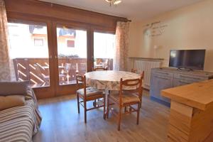 a living room with a table and chairs and a couch at MIKI APARTMENT MhD in Madonna di Campiglio +19 photos