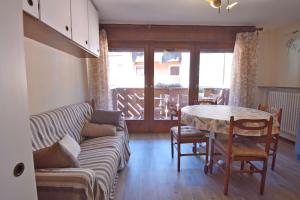 a living room with a couch and a table at MIKI APARTMENT MhD in Madonna di Campiglio