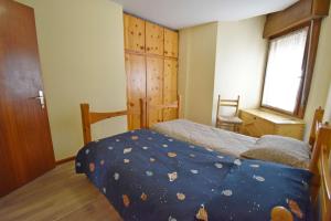 a small bedroom with a bed and a window at MIKI APARTMENT MhD in Madonna di Campiglio