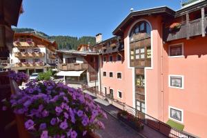 a view of a town with purple flowers on a balcony at MIKI APARTMENT MhD in Madonna di Campiglio