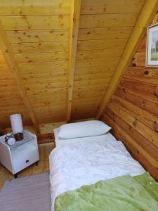 ein Schlafzimmer mit einem Bett in einer Holzhütte in der Unterkunft Auszeit im Oderbruch in Letschin