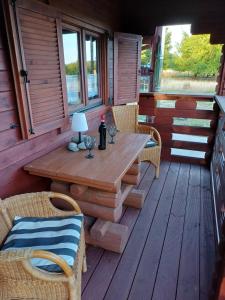 eine Holzterrasse mit Tisch und Stühlen auf einer Veranda in der Unterkunft Auszeit im Oderbruch in Letschin