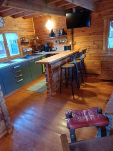 Eine Küche mit Bar und Hockern in einer Hütte in der Unterkunft Auszeit im Oderbruch in Letschin