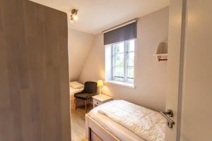 a small room with a bed and a window at Doppelhaushälfte OHANA in Böhl