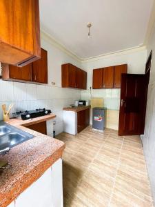 a kitchen with wooden cabinets and a wooden floor at Happy homes stay in Namugongo