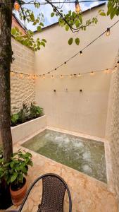 a hot tub in a patio with a chair and lights at Nam Hotel Boutique Medellin in Medellín