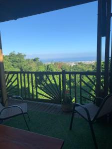 a porch with chairs and a view of the forest at studio P ti koin trankil in La Possession