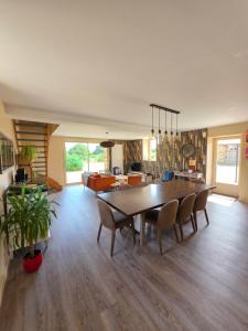 a dining room and living room with a table and chairs at Mon Pré Vert in Saint-Ellier-du-Maine
