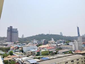a city with buildings and a hill in the background at Yensabai Condotel in Pattaya South