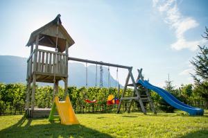 a playground with a slide and a swing at Ferienwohnungen Tollhof - Near Bolzano and castles, with a guest card for families and couples, offering panoramic views in Cornaiano