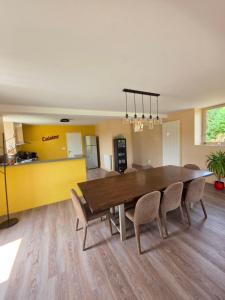 a dining room with a wooden table and chairs at Mon Pré Vert in Saint-Ellier-du-Maine