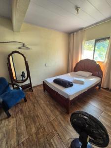 a bedroom with a bed and a mirror and a chair at pousada do vovo pescador in Juatuba