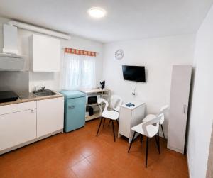 a kitchen with white cabinets and a table and chairs at Casa Marzoa in Finisterre