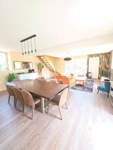 a dining room and living room with a table and chairs at Mon Pré Vert in Saint-Ellier-du-Maine
