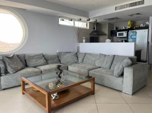 a living room with a gray couch and a coffee table at Bay View Grand Marina with jacuzzi- North Tower in Ixtapa