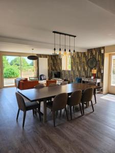 a dining room with a table and chairs at Mon Pré Vert in Saint-Ellier-du-Maine +24 photos