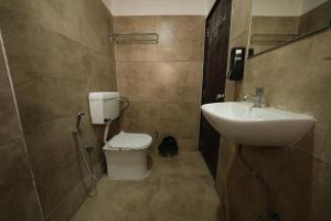a bathroom with a toilet and a sink at Hotel Ratan International in Raipur +1 photo