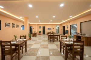 a dining room with wooden tables and chairs at Hotel Ratan International in Raipur