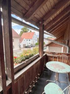 a porch with a table and chairs and a window at Ferienwohnung am Klöckhof in Marktoberdorf
