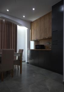 a kitchen with wooden cabinets and a dining table at Villa Lumi Mat in (( Mal i Kakariqit ))