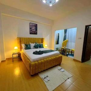 a bedroom with a large bed with a tufted headboard at Qwema Guest House in Nairobi