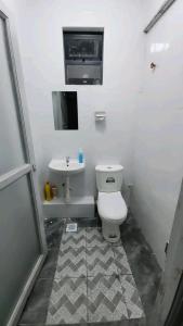 a bathroom with a toilet and a sink at Qwema Guest House in Nairobi