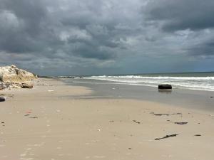 ein Strand mit bewölktem Himmel und dem Meer in der Unterkunft Residence BASI - Appartement 2 chambres in Rufisque