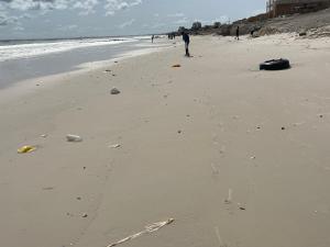 Eine Person steht an einem Strand in der Nähe des Ozeans in der Unterkunft Residence BASI - Appartement 2 chambres in Rufisque