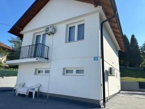 a white building with two chairs and a balcony at Sarajevo Corner in Gladno Polje