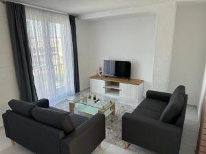 a living room with two couches and a tv at Sarajevo Corner in Gladno Polje