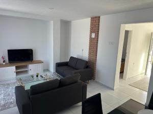 a living room with a couch and a tv at Sarajevo Corner in Gladno Polje +6 photos