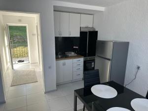 a small kitchen with a refrigerator and a table at Sarajevo Corner in Gladno Polje