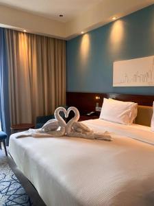 two swans made out of towels on a bed at Charlie Hotel in Kakani +1 photo