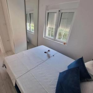 a white bed in a room with two windows at Lux apartmani boka in Tivat