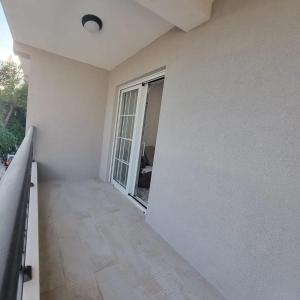 an empty room with a white wall and a window at Lux apartmani boka in Tivat +1 photo
