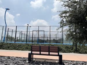 a park bench sitting in front of a fence at Departamento iluminado ideal para descansar in Miranda +6 photos