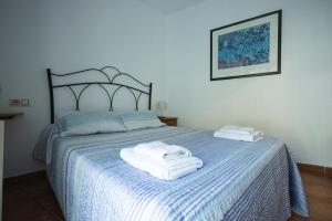 a bedroom with a bed with towels on it at Casa Ribera de Cazorla in Cazorla