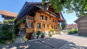 a large wooden house with a gambrel roof at bed and breakfast Liechti in Wattenwil