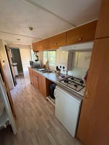 a small kitchen with a stove and a sink at Domek nad rozlewiskiem in Klotyldzin +12 photos