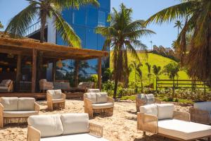 a resort with palm trees and chairs and a building at Tauá Hotel e Convention João pessoa in João Pessoa
