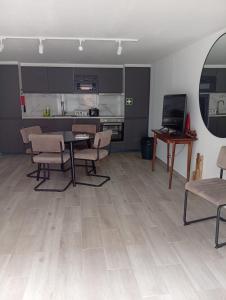 a living room with a table and chairs and a kitchen at Carregado Groundfloor in Carregado