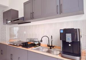 a kitchen counter with a sink and a water dispenser at Gamuda Cove 4BR SplashMania in Banting