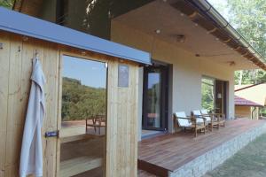 a house with a wooden deck with a patio at BOHO Forest Retreat in Novo Mesto