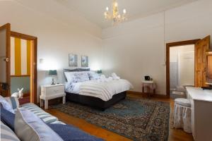 a bedroom with a bed and a couch in it at The Old Watchmakers Guest House in Bethulie