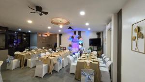 a banquet hall with white tables and white chairs at La Casa Princesa Inn in Puerto Princesa City