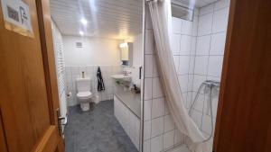 a white bathroom with a toilet and a sink at bed and breakfast Liechti in Wattenwil +17 photos