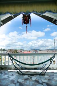 a hammock on a balcony with a view at Pensee Guesthouse in Da Lat