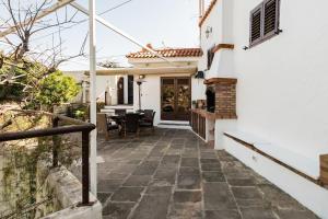 a white house with a patio with a table at Casa Huertas del Palmar in Teror