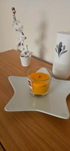 a bowl of orange liquid on a plate on a table at Ketty apartments in Niš +15 photos