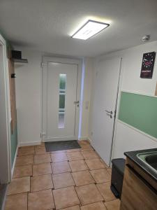 a kitchen with a door and a tile floor at Ferienwohnung beim Belchen in Wieden